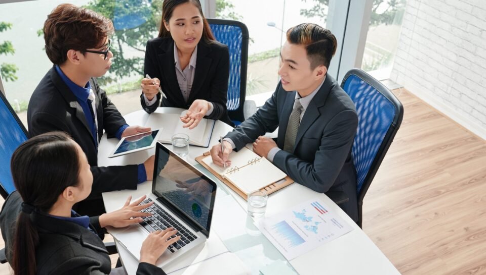 Ambitious group of business people brainstorming on project while having working meeting in modern boardroom, high angle view